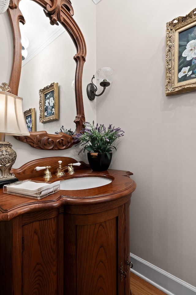 bathroom with hardwood / wood-style floors, vanity, and crown molding