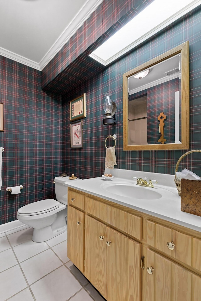 bathroom with tile patterned floors, crown molding, vanity, and toilet