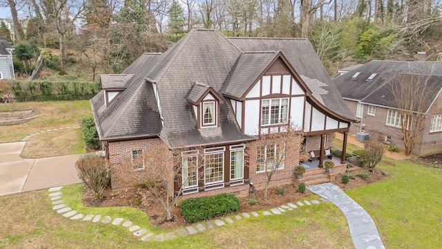 exterior space featuring central AC unit, covered porch, and a front lawn