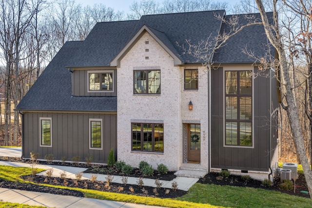 view of front of house featuring cooling unit and a front yard