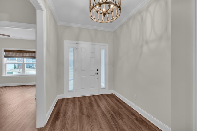 entryway featuring a chandelier, ornamental molding, and dark wood-type flooring