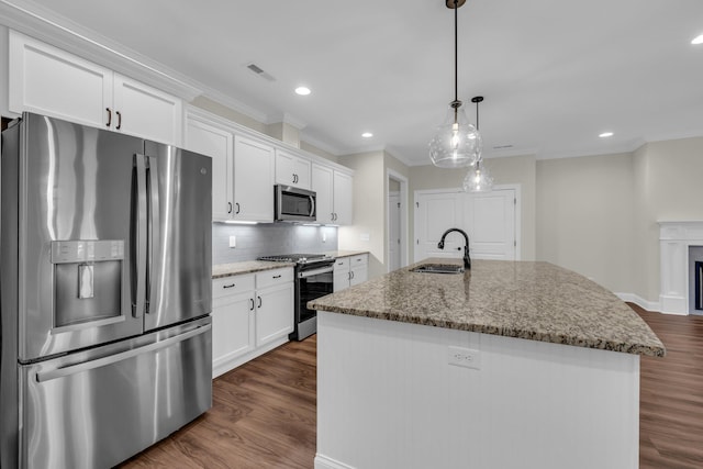 kitchen featuring white cabinetry, light stone counters, decorative light fixtures, a kitchen island with sink, and appliances with stainless steel finishes