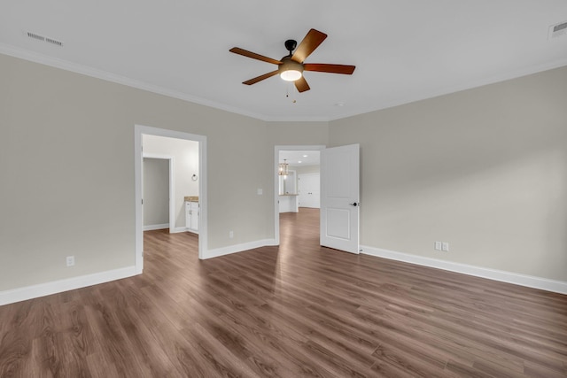 spare room featuring ceiling fan with notable chandelier, ornamental molding, and dark wood-type flooring