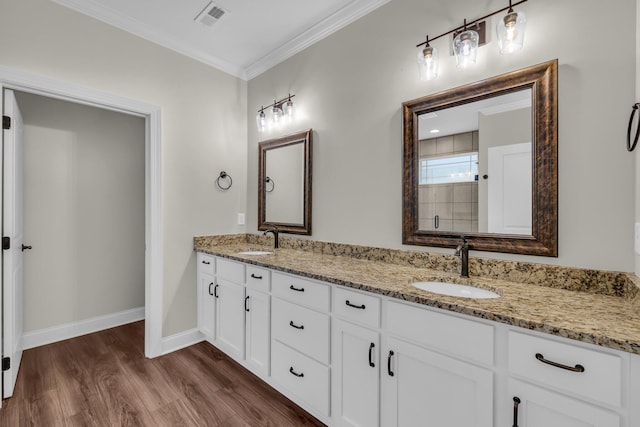 bathroom featuring vanity, wood-type flooring, and crown molding