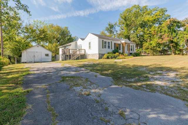 view of front facade featuring a front lawn and a storage shed