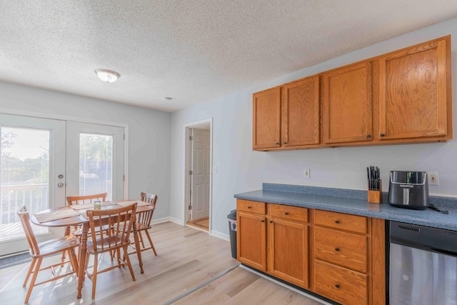 kitchen featuring french doors, dishwasher, light hardwood / wood-style floors, and a textured ceiling