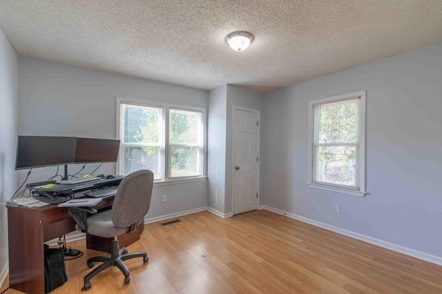 office area featuring a textured ceiling and light hardwood / wood-style flooring