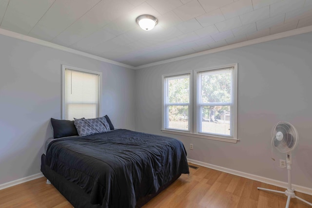 bedroom with light hardwood / wood-style flooring and ornamental molding