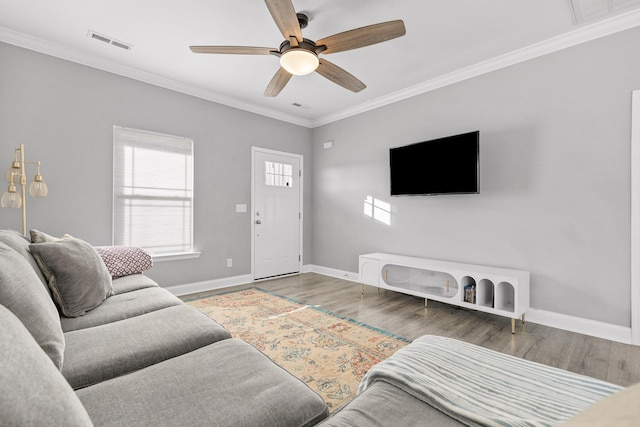 living room featuring wood-type flooring, ceiling fan, and crown molding