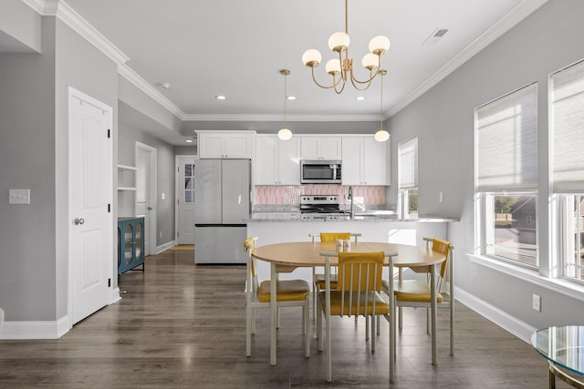 dining space with dark wood-type flooring, crown molding, and a chandelier