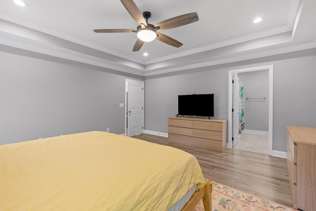 bedroom with a tray ceiling, ceiling fan, light hardwood / wood-style flooring, and crown molding