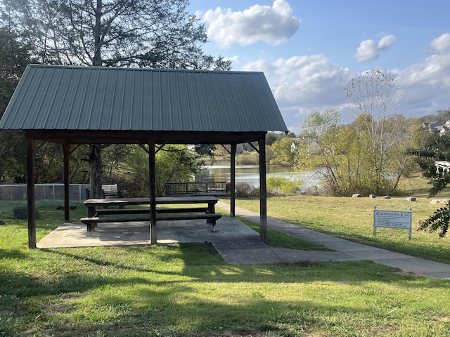 view of property's community featuring a gazebo, a water view, and a lawn