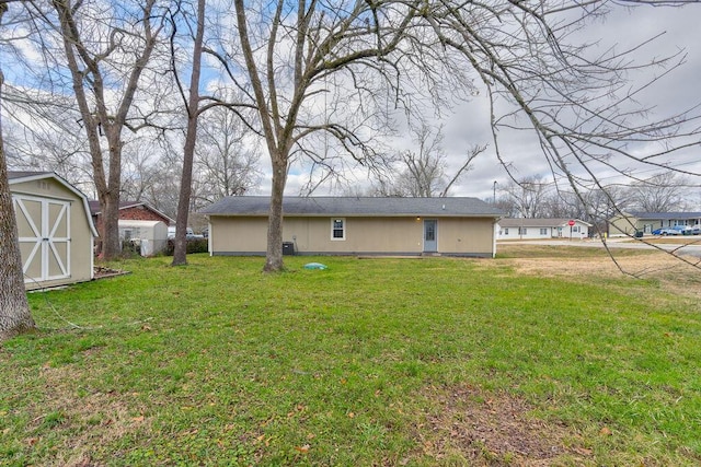 rear view of house featuring a storage unit and a lawn