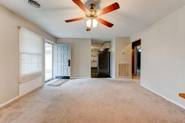 unfurnished living room featuring ceiling fan and light carpet