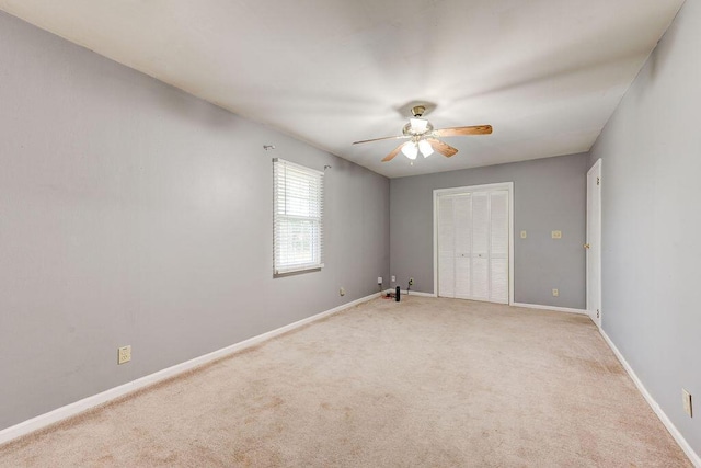 empty room with ceiling fan and light colored carpet