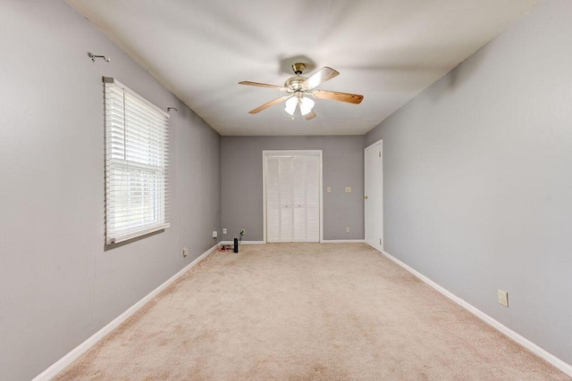 carpeted empty room featuring ceiling fan