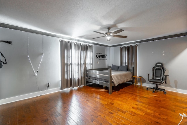 unfurnished bedroom featuring ceiling fan, a textured ceiling, and hardwood / wood-style floors