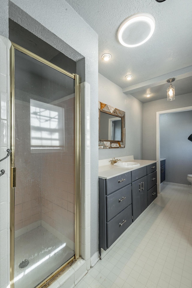 bathroom featuring walk in shower, vanity, and a textured ceiling