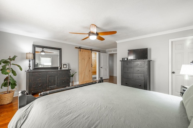 bedroom featuring ceiling fan, ornamental molding, and a barn door