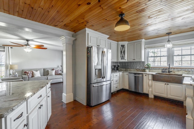 kitchen featuring white cabinets, appliances with stainless steel finishes, sink, hanging light fixtures, and wooden ceiling