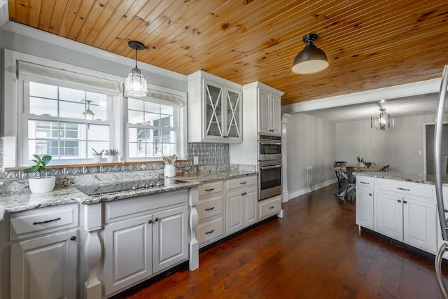 kitchen with wooden ceiling, white cabinetry, black electric stovetop, and hanging light fixtures