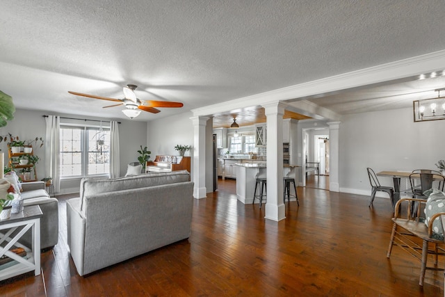 living room featuring a textured ceiling, ceiling fan, dark hardwood / wood-style flooring, and decorative columns