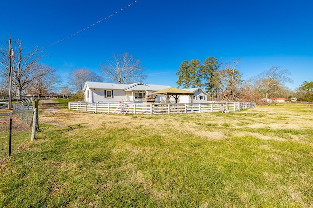 rear view of house featuring a gazebo, a yard, and a rural view