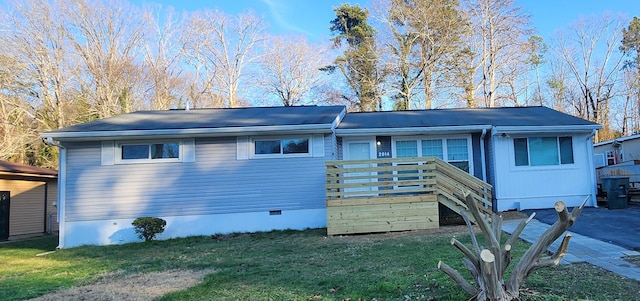 view of front of home with a wooden deck and a front lawn