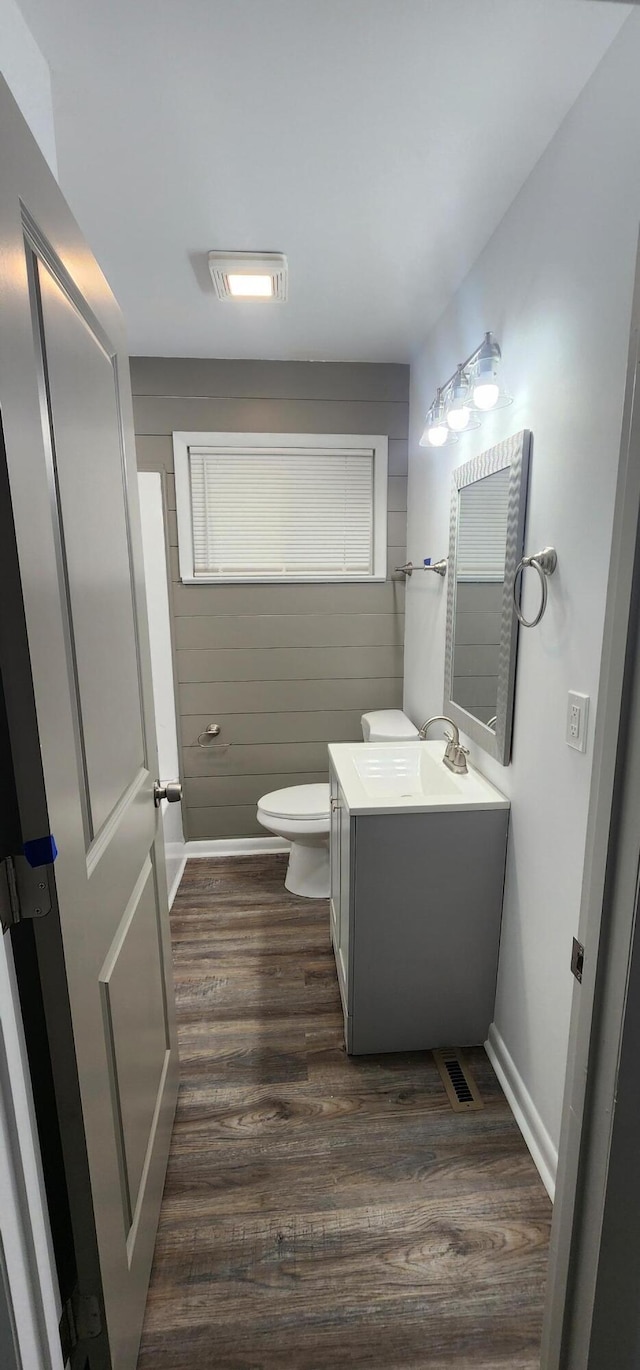 bathroom with hardwood / wood-style floors, vanity, and toilet