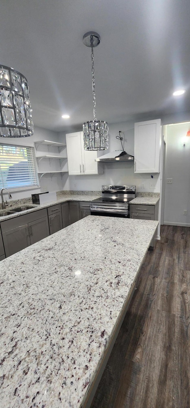 kitchen featuring white cabinetry, sink, light stone counters, pendant lighting, and stainless steel electric stove