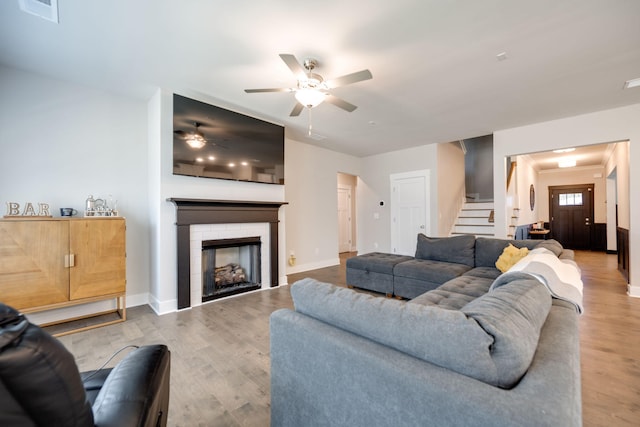 living room featuring ceiling fan and light hardwood / wood-style flooring