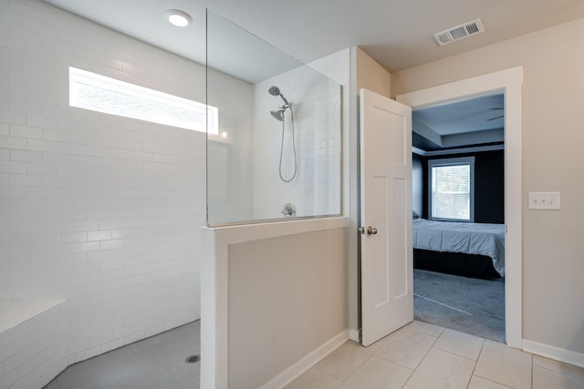 bathroom with tile patterned floors and a tile shower