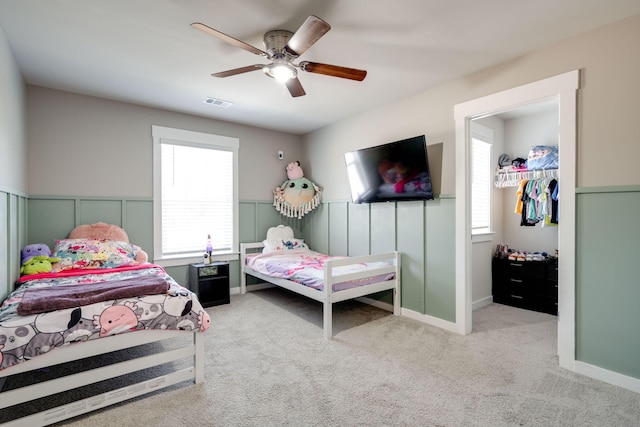 carpeted bedroom featuring multiple windows and ceiling fan