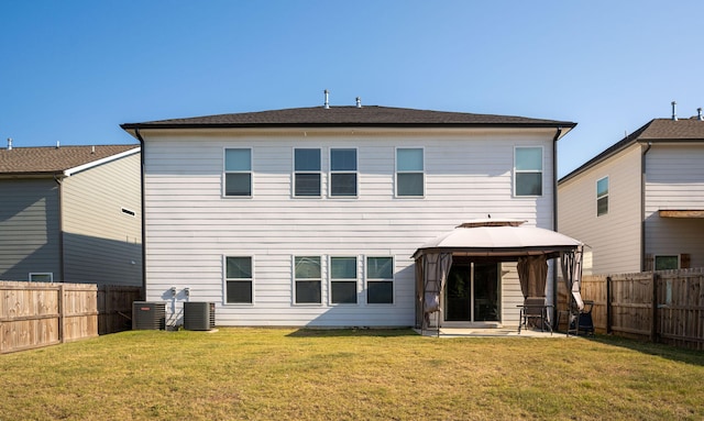 rear view of property with a gazebo, cooling unit, and a lawn