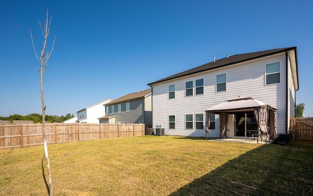 back of property with a gazebo, cooling unit, a patio area, and a lawn