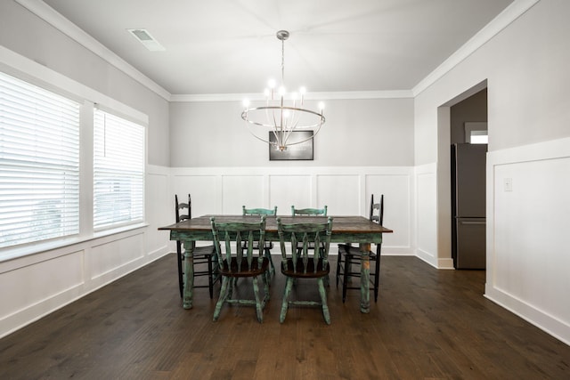 dining room with dark hardwood / wood-style floors, an inviting chandelier, and crown molding