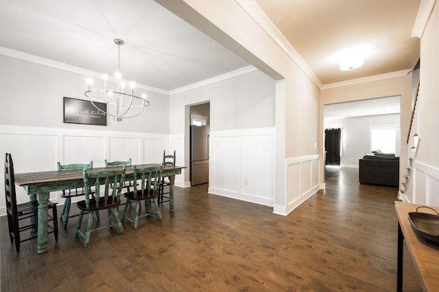 dining area with crown molding, dark wood-type flooring, and an inviting chandelier