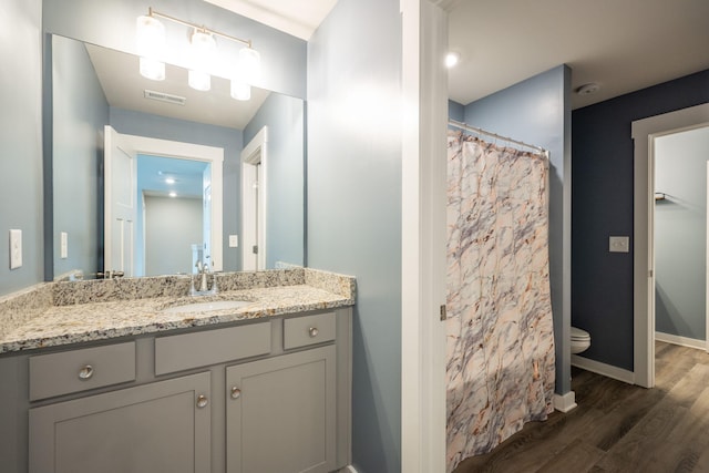 8784 Snowy Owl Rd, Ooltewah, TN 37363 - full bathroom featuring visible vents, vanity, wood finished floors, toilet, and baseboards