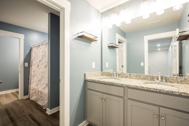 8784 Snowy Owl Rd, Ooltewah, TN 37363 - bathroom with double vanity, visible vents, a sink, and wood finished floors