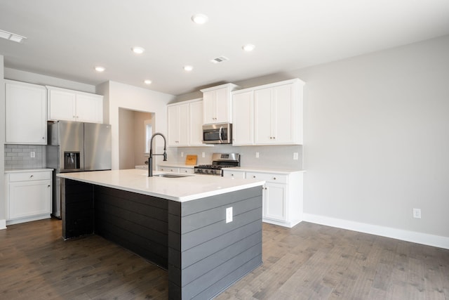 8784 Snowy Owl Rd, Ooltewah, TN 37363 - kitchen featuring visible vents, appliances with stainless steel finishes, tasteful backsplash, a sink, and dark wood-type flooring