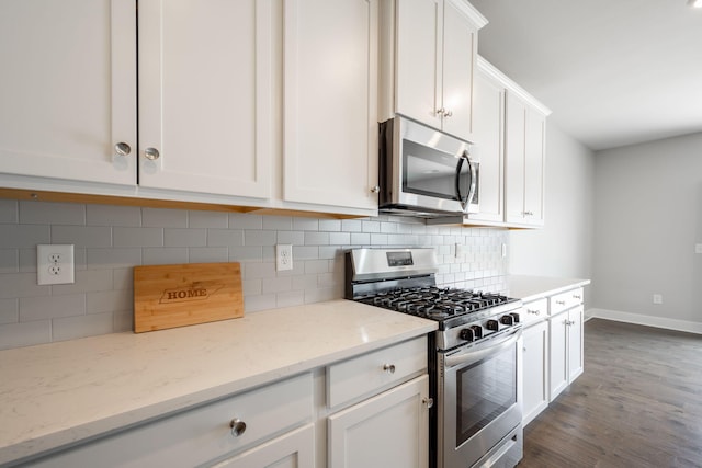 8784 Snowy Owl Rd, Ooltewah, TN 37363 - kitchen with stainless steel appliances, baseboards, white cabinetry, decorative backsplash, and dark wood-style floors