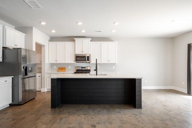 8784 Snowy Owl Rd, Ooltewah, TN 37363 - kitchen featuring a kitchen island with sink, dark wood-type flooring, tasteful backsplash, a sink, and appliances with stainless steel finishes