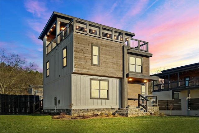 back house at dusk featuring a yard