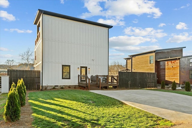 rear view of house featuring a yard and a wooden deck