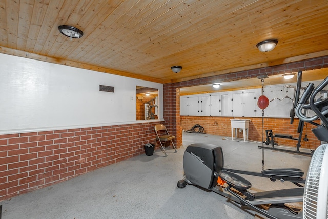 workout room with wood ceiling and brick wall