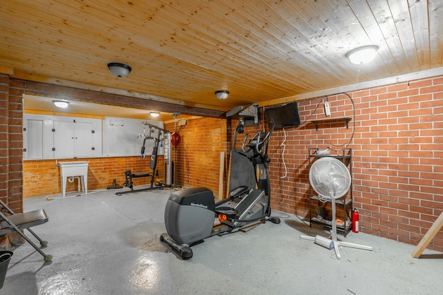 exercise area featuring wooden ceiling and brick wall