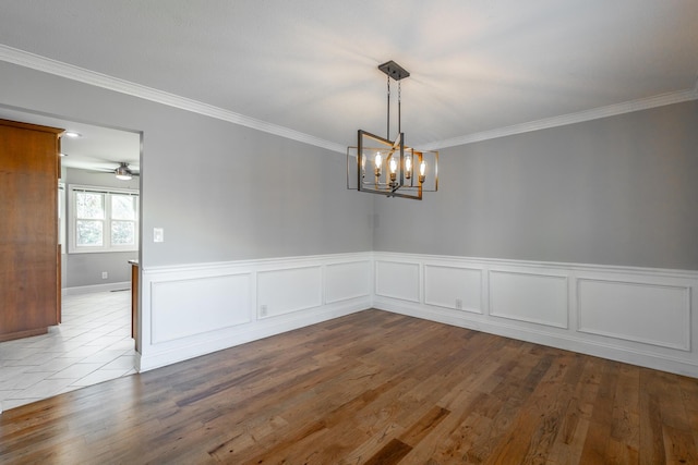 empty room featuring crown molding, a notable chandelier, and hardwood / wood-style flooring