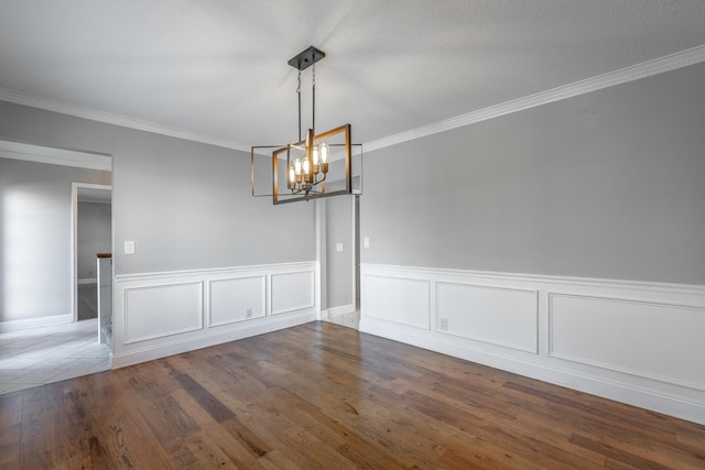 spare room with ornamental molding, dark hardwood / wood-style floors, and a notable chandelier