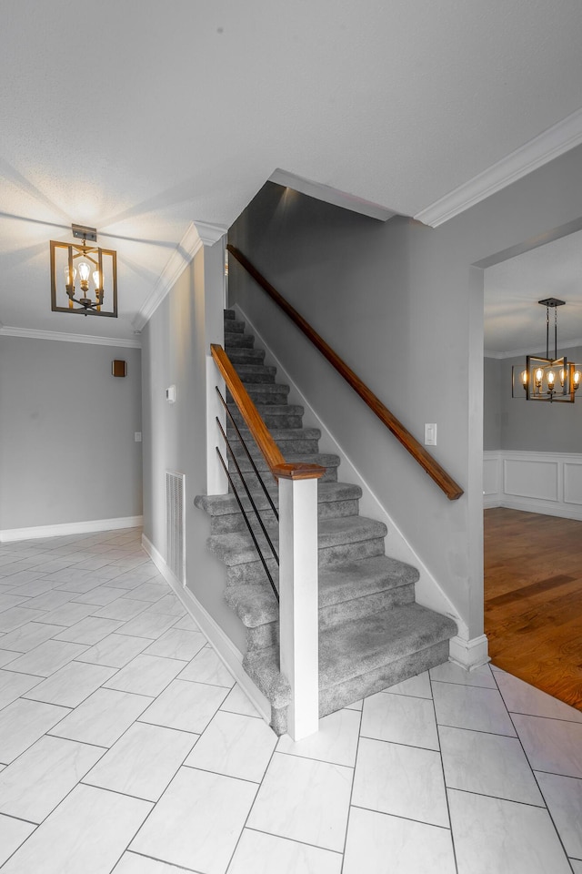 staircase featuring tile patterned floors, a notable chandelier, and crown molding