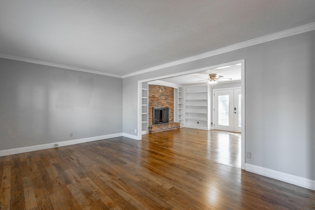 unfurnished living room featuring built in shelves, crown molding, dark hardwood / wood-style flooring, and ceiling fan